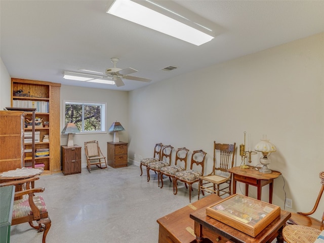 sitting room with concrete flooring and ceiling fan