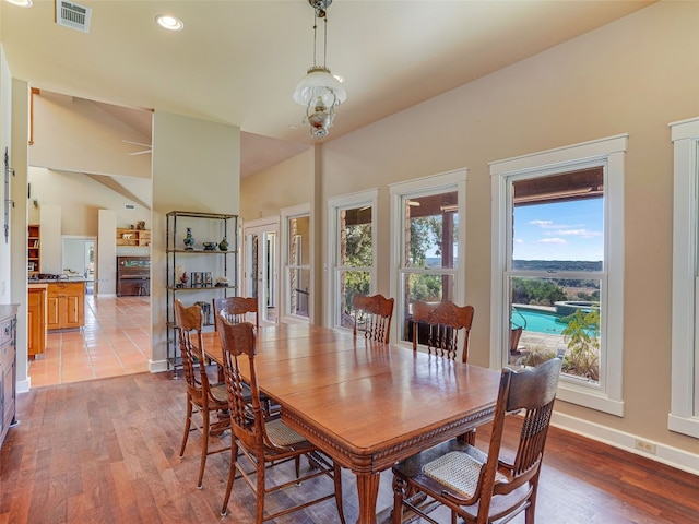 dining room featuring lofted ceiling, light hardwood / wood-style floors, and a notable chandelier