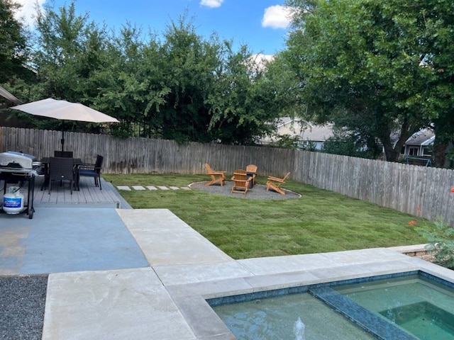 view of yard featuring a fire pit, a patio area, an in ground hot tub, and a wooden deck