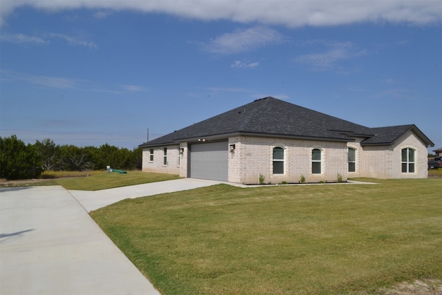 view of side of property with a garage and a lawn