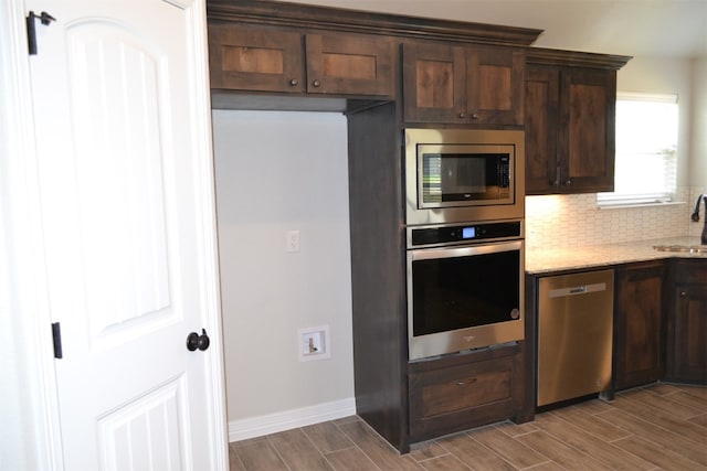 kitchen with dark brown cabinets, wood-type flooring, and appliances with stainless steel finishes