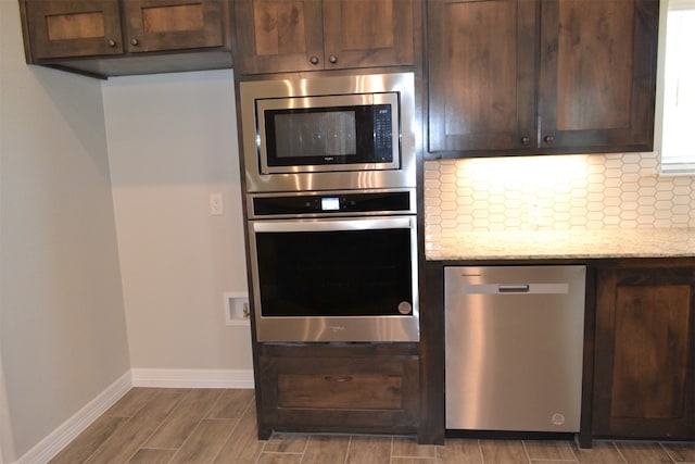 kitchen featuring dark brown cabinets, light stone countertops, and stainless steel appliances