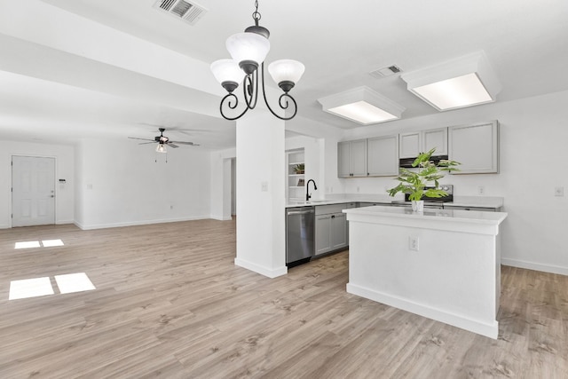 kitchen featuring dishwasher, ceiling fan with notable chandelier, gray cabinets, decorative light fixtures, and light hardwood / wood-style floors