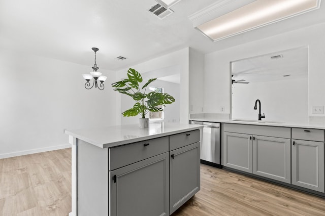 kitchen with gray cabinetry, sink, stainless steel dishwasher, and light hardwood / wood-style flooring