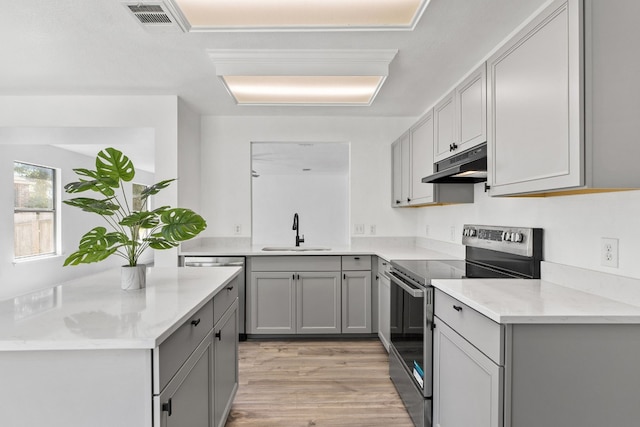 7913 Eudora Ln, Austin, TX 78747 - kitchen featuring appliances with stainless steel finishes, a sink, under cabinet range hood, and gray cabinets