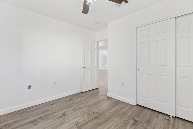 unfurnished bedroom with ceiling fan, a closet, and light hardwood / wood-style flooring