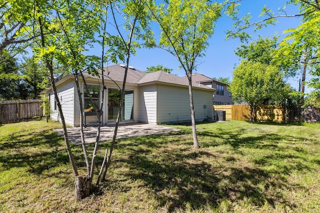 rear view of house featuring central AC unit, a patio area, and a lawn