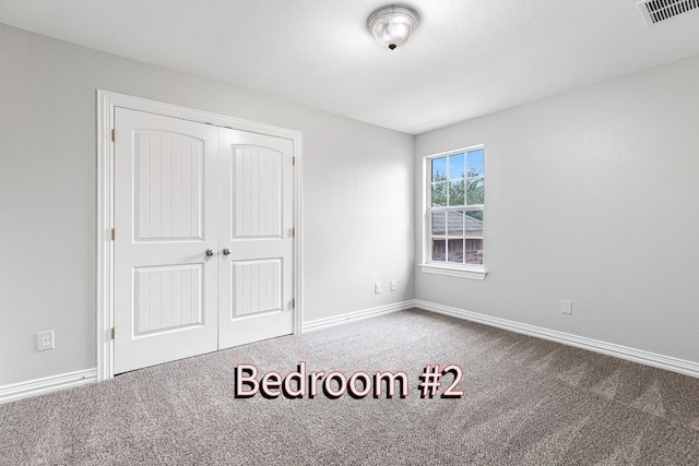 unfurnished bedroom featuring carpet and a closet