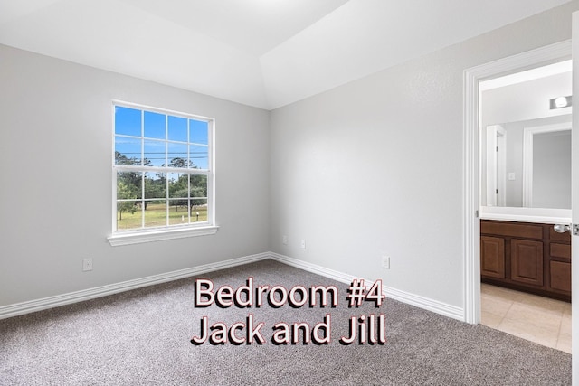 unfurnished bedroom with connected bathroom and light colored carpet