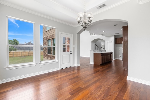 unfurnished living room with sink, crown molding, dark wood-type flooring, and a chandelier