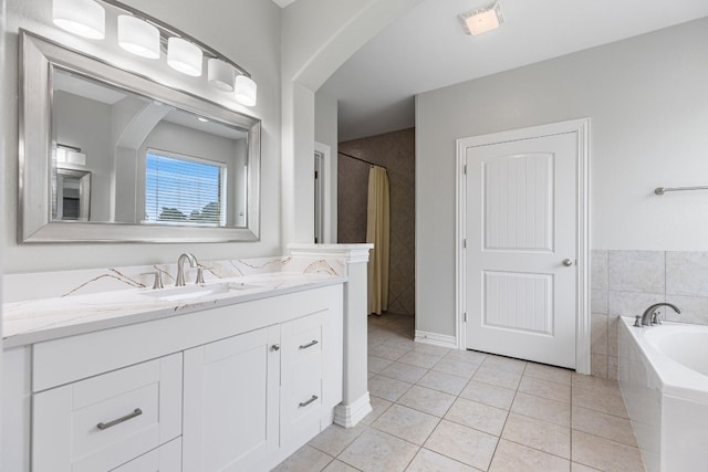 bathroom featuring vanity, a tub to relax in, and tile patterned floors