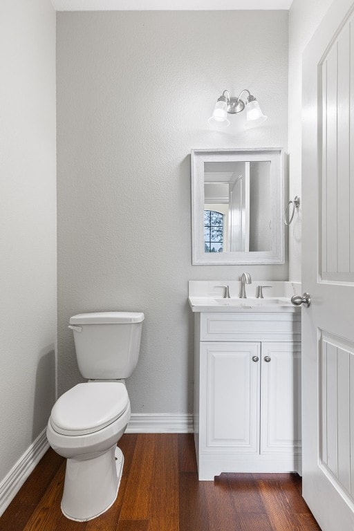 bathroom with hardwood / wood-style floors, vanity, and toilet