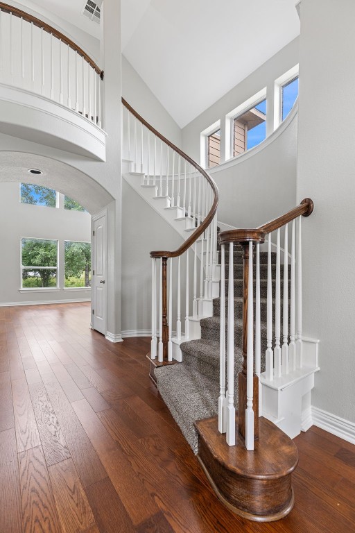 foyer entrance featuring plenty of natural light, high vaulted ceiling, and dark hardwood / wood-style floors