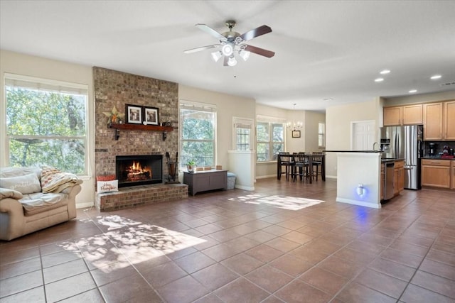 unfurnished living room with a healthy amount of sunlight, a brick fireplace, dark tile patterned floors, and recessed lighting