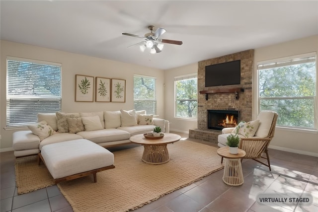 living area with a healthy amount of sunlight, a fireplace, baseboards, and tile patterned floors