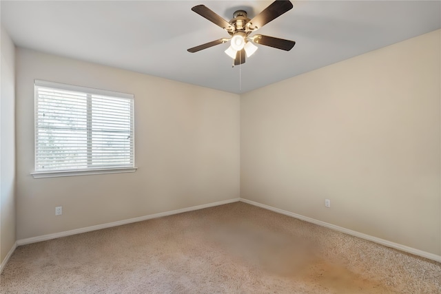 empty room with a ceiling fan, light colored carpet, and baseboards