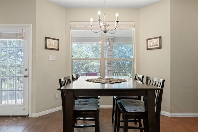 tiled dining space with a healthy amount of sunlight, baseboards, and a chandelier