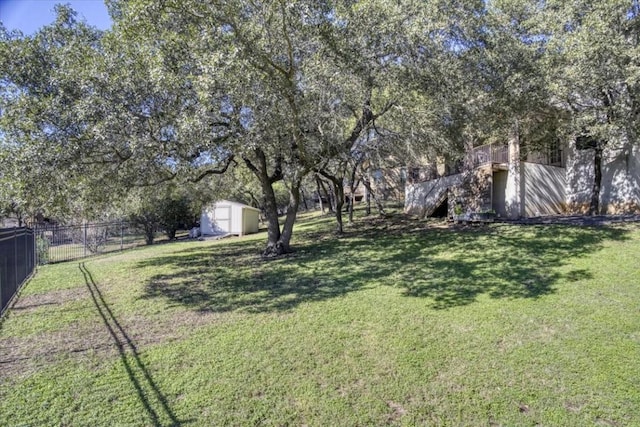 view of yard with fence, an outdoor structure, and a shed