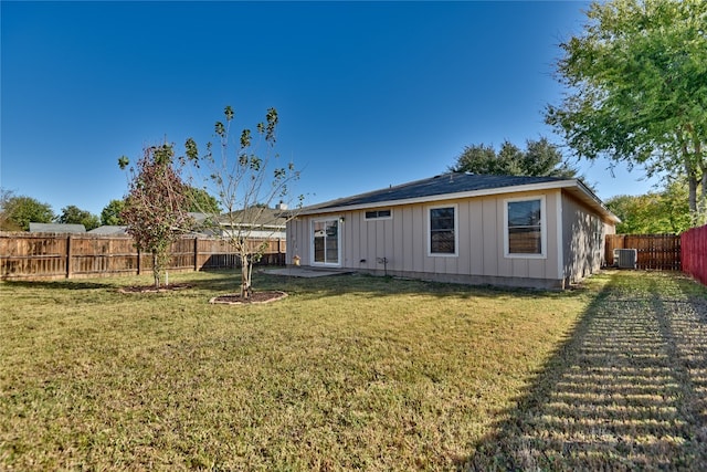 back of property featuring cooling unit and a yard