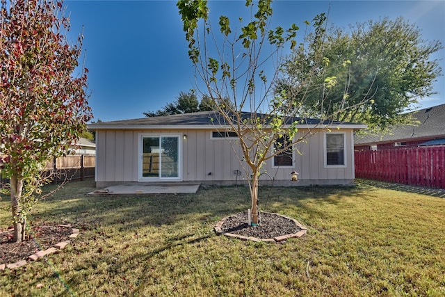 back of house featuring a lawn and a patio