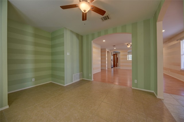 spare room featuring ceiling fan, light hardwood / wood-style floors, and plenty of natural light