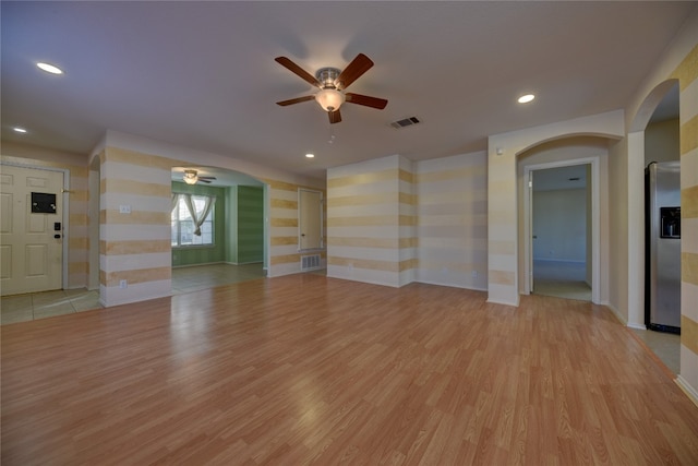 unfurnished living room featuring ceiling fan and light hardwood / wood-style flooring