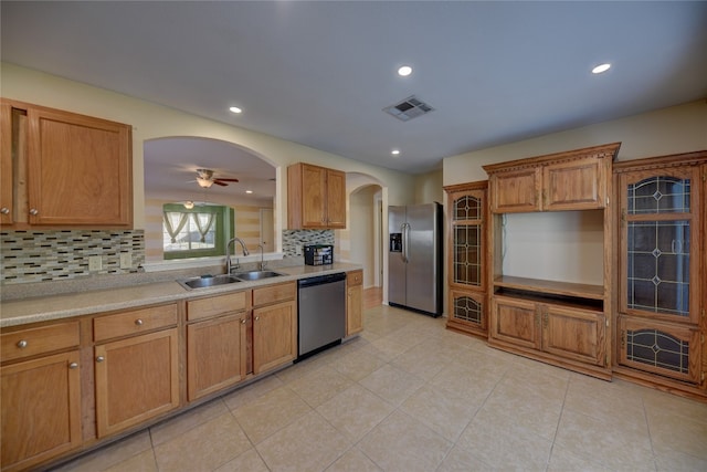 kitchen featuring ceiling fan, sink, stainless steel appliances, decorative backsplash, and light tile patterned floors