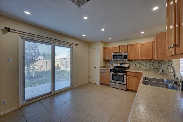 kitchen featuring light tile patterned flooring, stainless steel appliances, tasteful backsplash, and sink