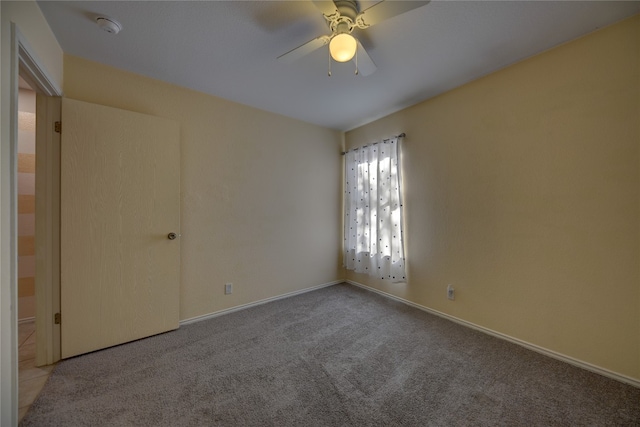 carpeted spare room featuring ceiling fan