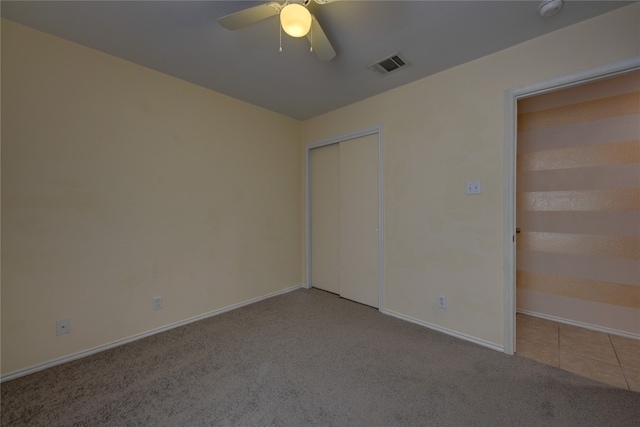 unfurnished bedroom featuring ceiling fan, a closet, and light colored carpet