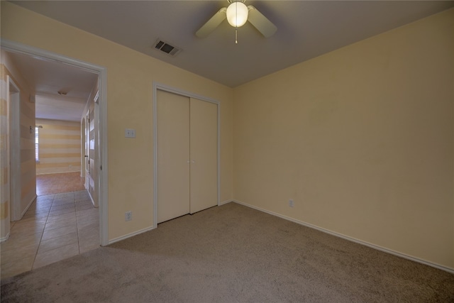 unfurnished bedroom featuring ceiling fan, a closet, and light carpet