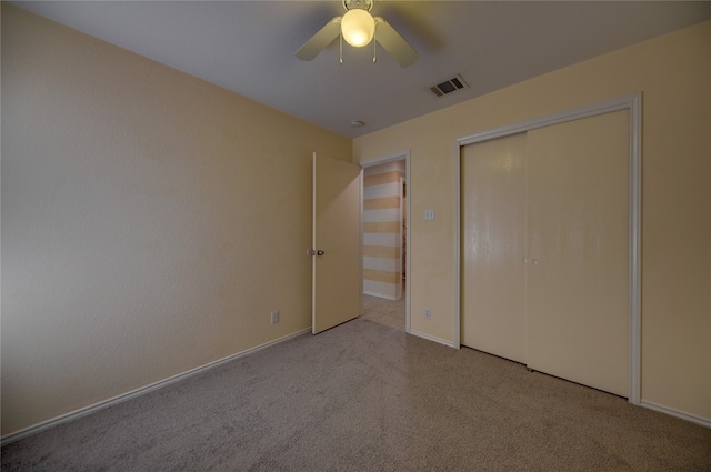 unfurnished bedroom featuring ceiling fan, a closet, and light carpet