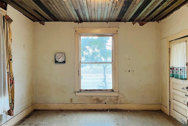 empty room with wood ceiling and a healthy amount of sunlight