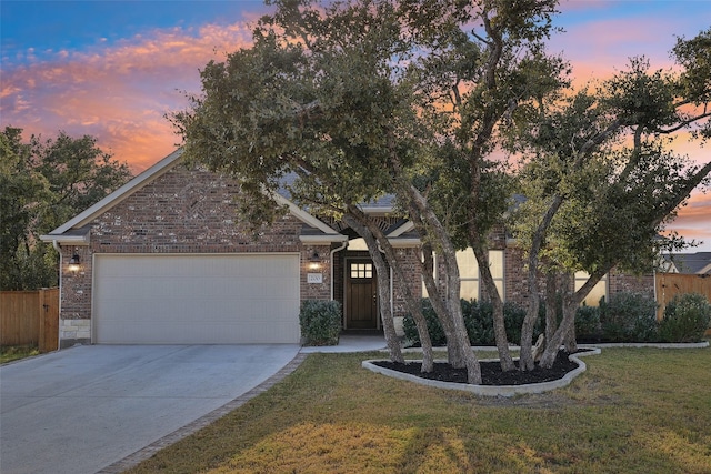 view of property hidden behind natural elements featuring a yard and a garage