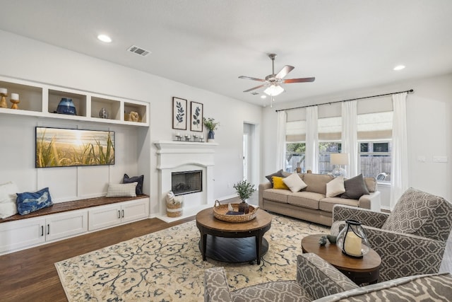 living room featuring ceiling fan and dark wood-type flooring