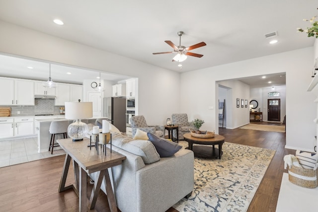 living room with hardwood / wood-style flooring and ceiling fan