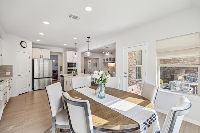 dining room featuring ceiling fan and sink