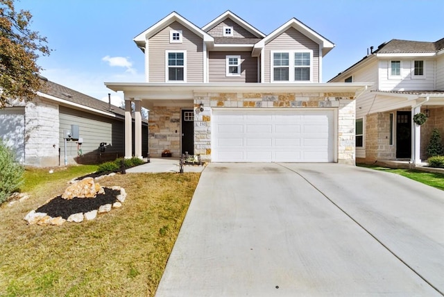 view of front of property with a front yard, stone siding, driveway, and an attached garage