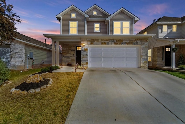 view of front of house with a yard, stone siding, driveway, and an attached garage