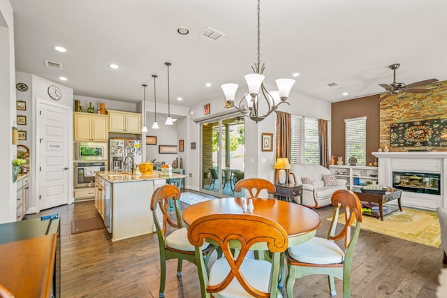 dining space featuring dark hardwood / wood-style flooring and ceiling fan with notable chandelier