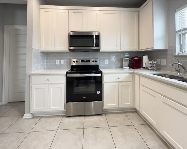 249 El Dorado Rd, Jarrell, TX 76537 - kitchen featuring appliances with stainless steel finishes, tasteful backsplash, light countertops, light tile patterned floors, and white cabinets
