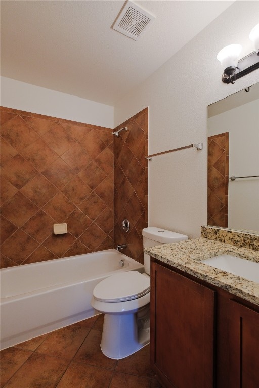 full bathroom featuring toilet, vanity, tile patterned floors, and tiled shower / bath