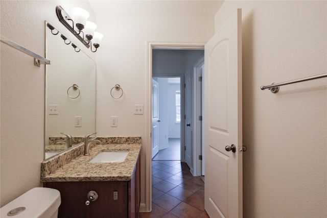 bathroom featuring tile patterned flooring, vanity, and toilet