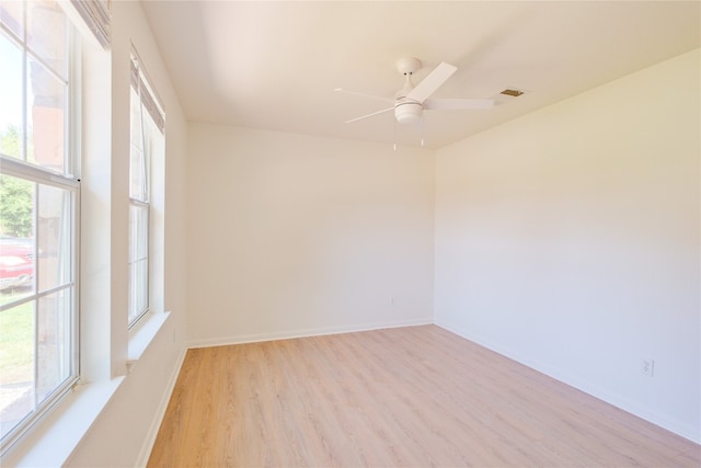 empty room featuring ceiling fan, light hardwood / wood-style flooring, and a healthy amount of sunlight