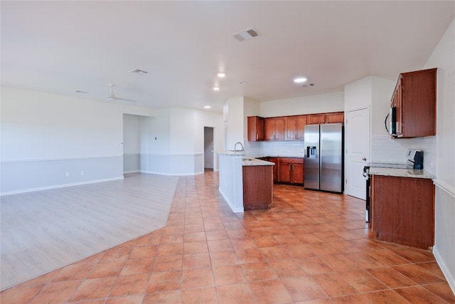 kitchen with tasteful backsplash, ceiling fan, sink, and stainless steel appliances