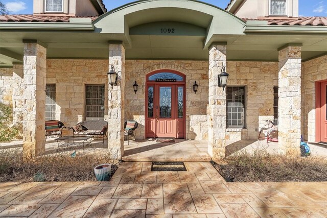 1092 Fm 3000, Elgin, TX 78621 - doorway to property with a porch, stone siding, and a tile roof