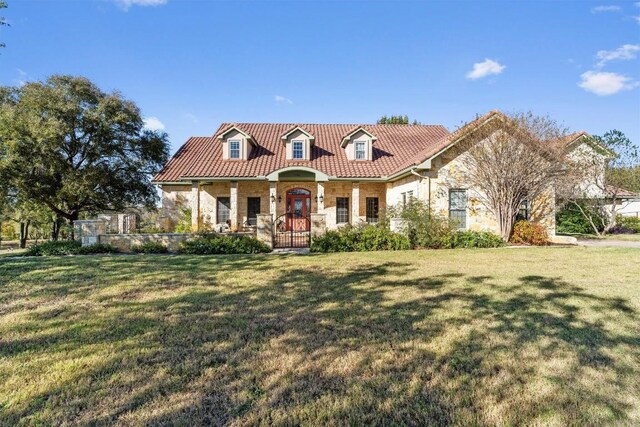 view of front facade featuring covered porch and a front yard