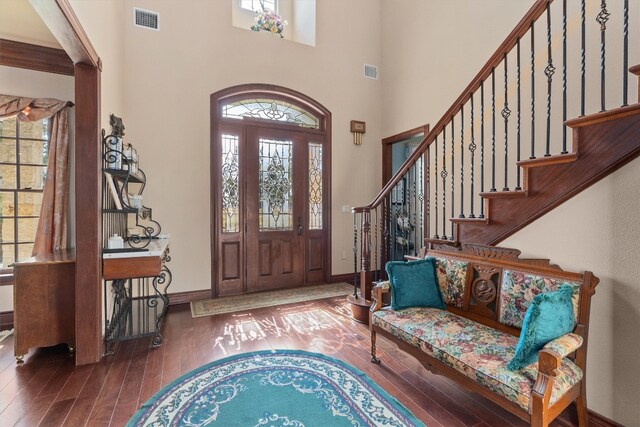 foyer entrance with a high ceiling and dark hardwood / wood-style floors