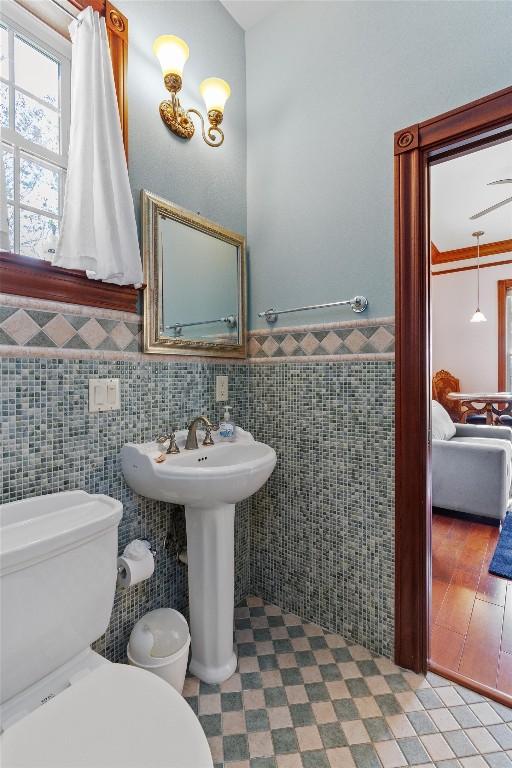 1092 Fm 3000, Elgin, TX 78621 - bathroom with tile walls, toilet, wainscoting, and a sink