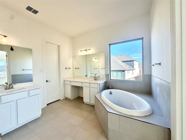 bathroom featuring vanity, tiled bath, and tile patterned floors